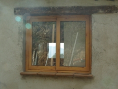 Ventana corredera, de aluminio imitacion madera, colocada en una casa de campo
