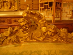 Detalle de copete de un sofa de silleria louis-xv en madera tallada y sobredorada