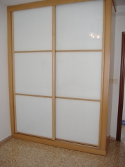 Armario empotrado: puertas de cristal blanco enmarcadas con perfil roble
