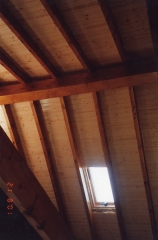 Techo de madera con ventanas en casa de obra