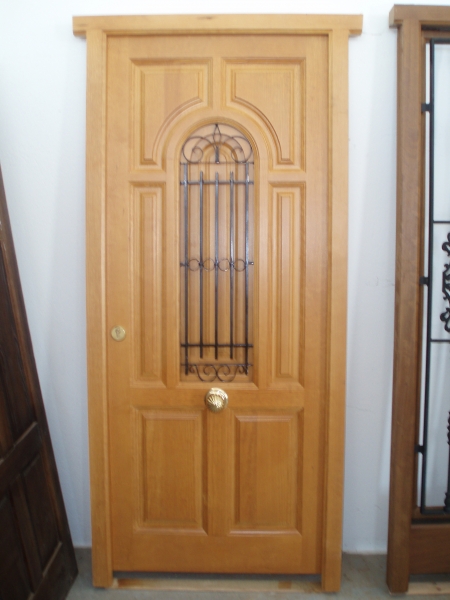 Puerta de Madera maciza de calle con reja de forja