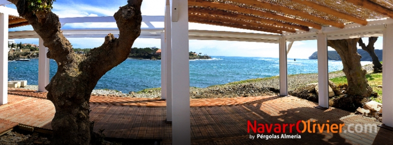 Terraza de chiringuito con pérgola cubierta en mimbre y suelo en tarima autoclave