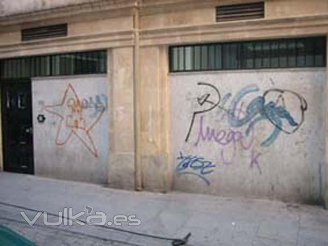 Fachada de granito al corte y piedra de Salamanca que presenta múltiples pintadas y restos de tratamientos ...