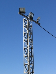 Alumbrado exterior de una industria con proyectores industriales de halogenuros metalicos sobre una torre metalica