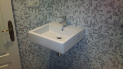 Bano con azulejo de mosaico con lavabo suspendido